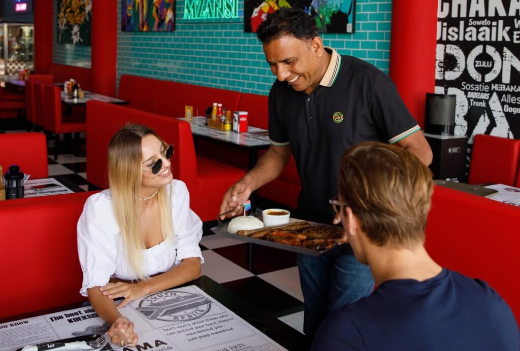 Server presenting meal to happy diners Hyperama Diner