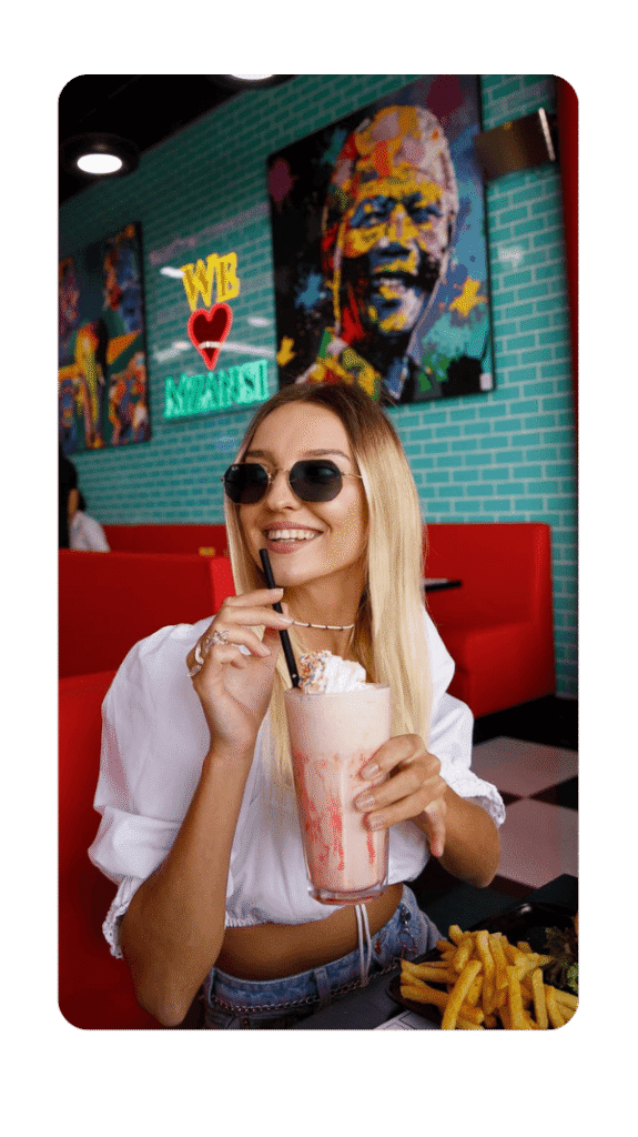beautiful lady with black glasses sipping shake from a glass