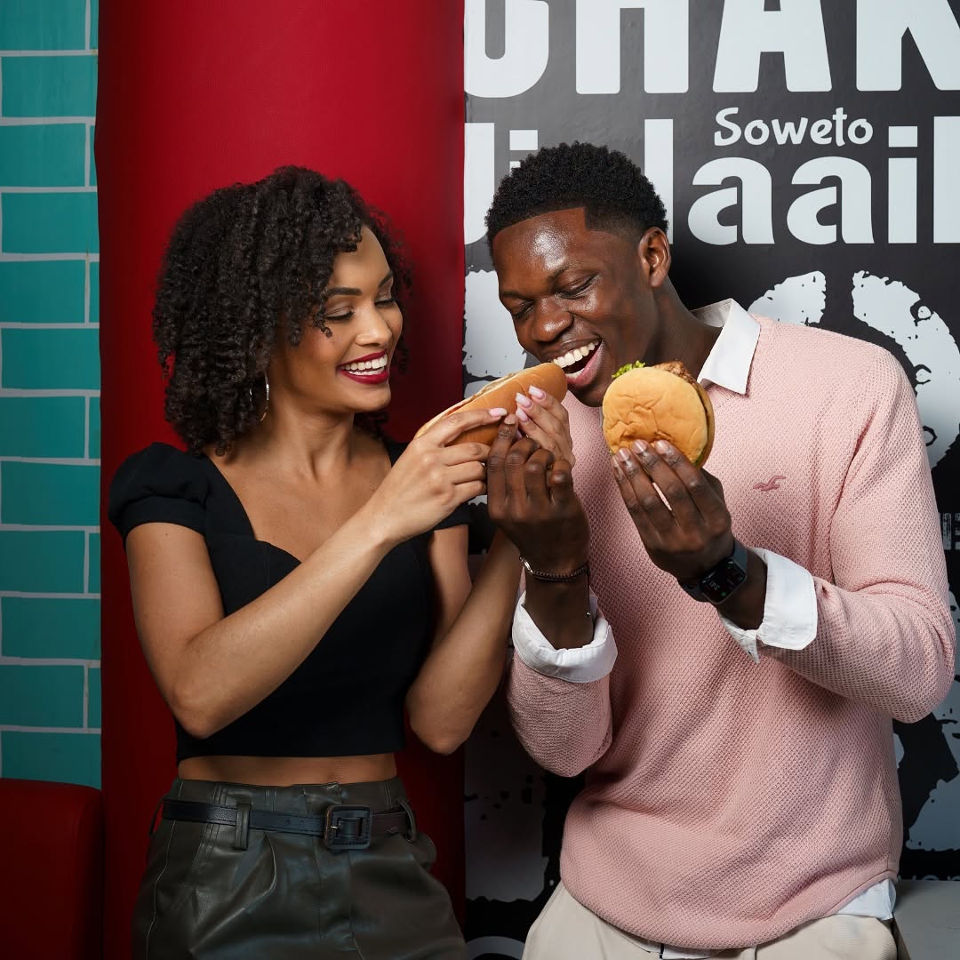 Happy young african couple enjoying burgers at Hyperama Diner