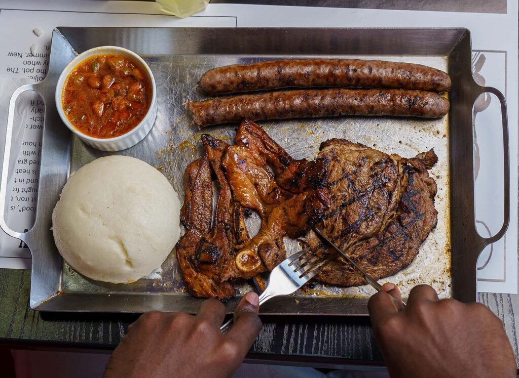 man eating south African steak with fork and knife