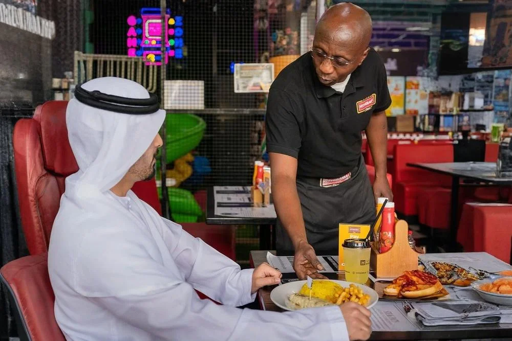 South African waiter entertaining Arab customer