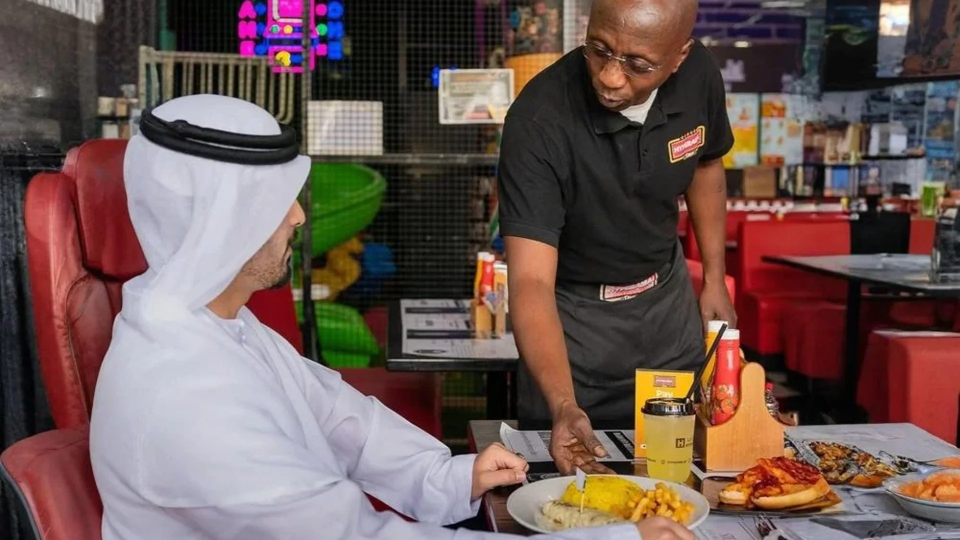 South African waiter entertaining Arab customer