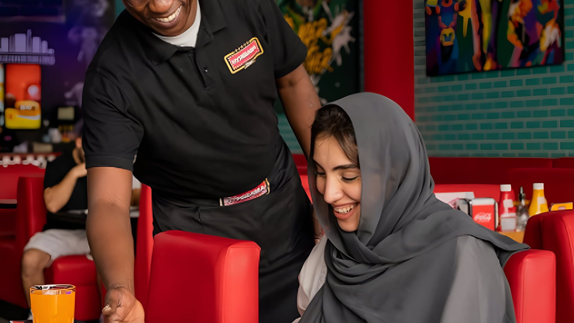 Server presenting a traditional South African meal to a diner at Hyperama Diner in Dubai